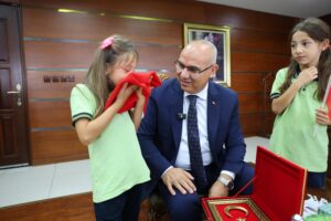 YERDE BULDUĞU BAYRAĞI ÖPÜP BAŞINA KOYAN MİNİK NEHİR’E VALİ KOÇ’TAN ANLAMLI ÖDÜL